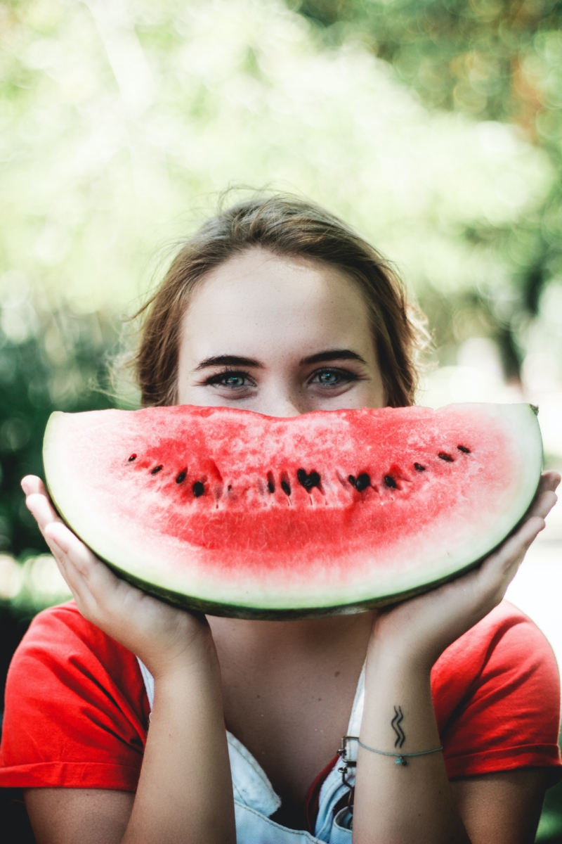 Frau hält leckere Melone vor ihr Gesicht